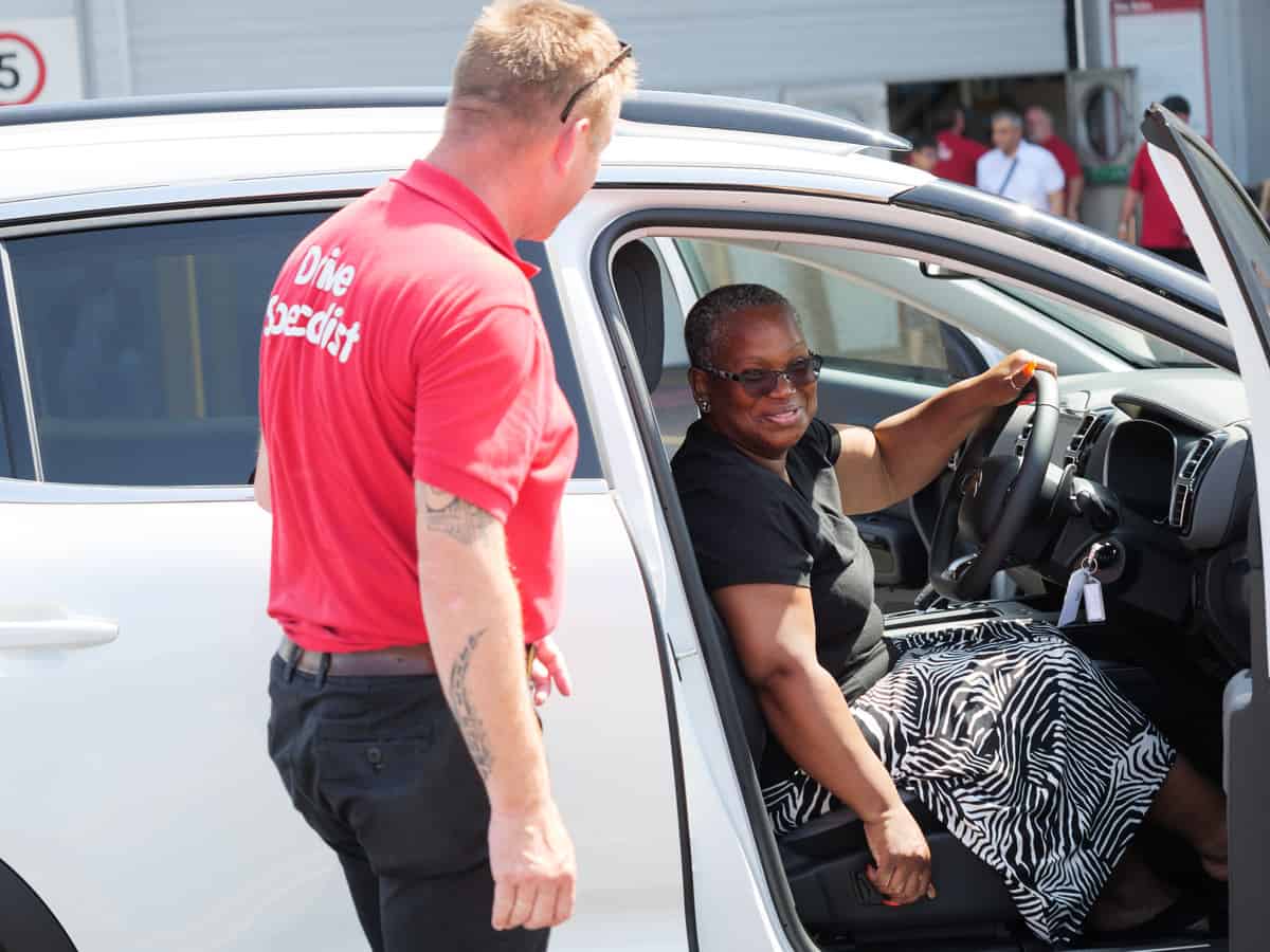 A person sitting in a car during a test drive with assistance