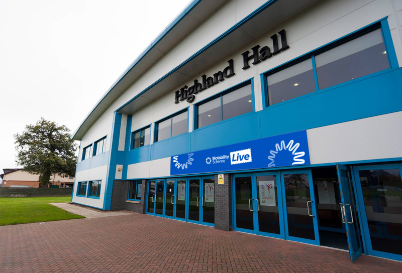 Entrance to Highland Hall with blue doors and a paved forecourt.