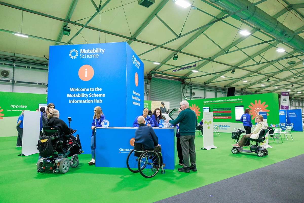 A large blue Motability Scheme Information Hub in the centre of an event hall